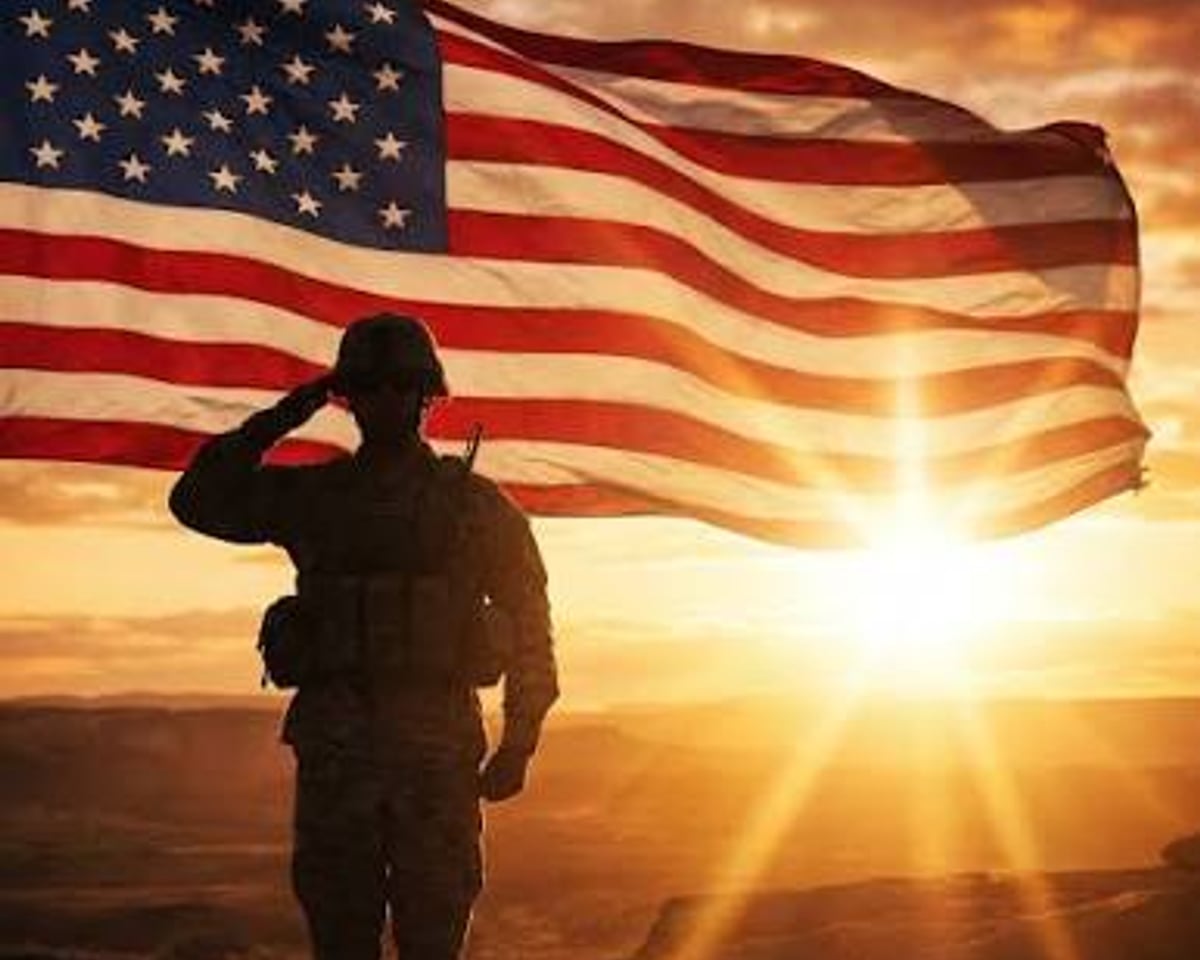 Silhouette of a service member saluting before the American flag at sunset
