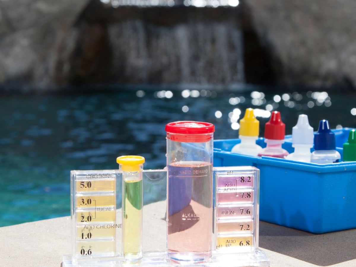 Pool water test kit and reagents on the pool deck