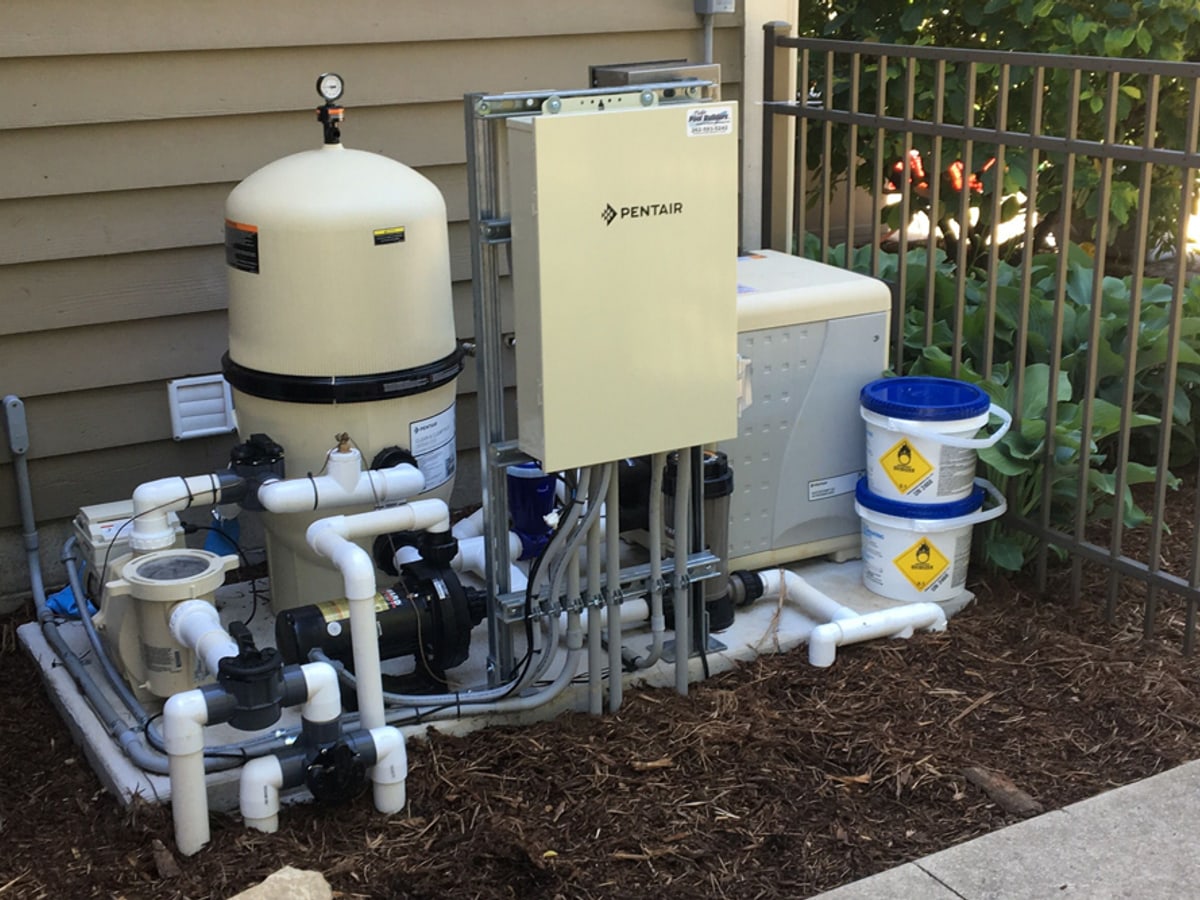 Residential pool equipment pad with pump, filter, heater, valves, and plumbing