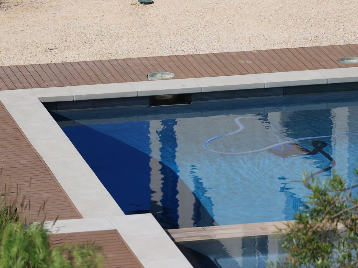Automatic pool cleaner hose in a clean residential backyard pool